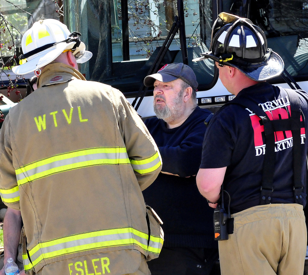 Homeowner Richard Leaman, center, speaks with Waterville firefighters Thursday as others put out a fire at his home in Waterville.