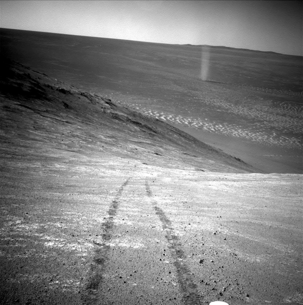 From its perch high on a ridge, the Mars rover Opportunity took this picture March 31 of a dust devil twisting through Mars' Marathon Valley below. The view looks back at the rover's tracks leading up the north-facing slope of Knudsen Ridge.