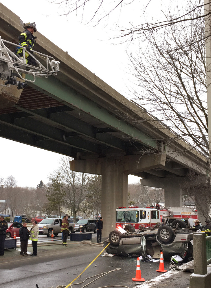 A Mercury Mountaineer rests on its roof in Bath after falling off the Route 1 viaduct Monday. A woman and her son were pulled from the SUV and transported to Maine Medical Center in Portland.