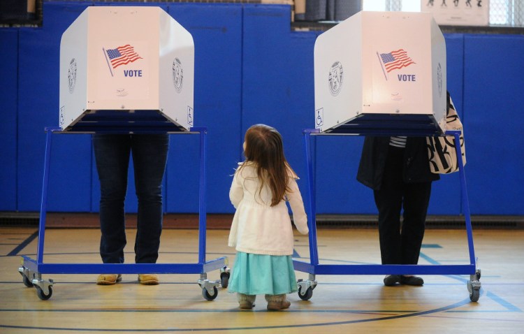 Brigit Mulligan, right, casts her vote as her daughter, Giovanna Candido, checks out a neighboring voter during a primary election at the Sanford St. School in Glens Falls, N.Y., on Tuesday.