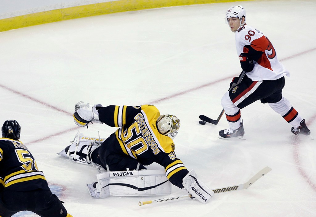 Boston Bruins goalie Jonas Gustavsson comes out to defend against Ottawa Senators right wing Alex Chiasson with  Bruins defenseman Adam McQuaid, below left, in the first period of Saturday's game in Boston. The Associated Press