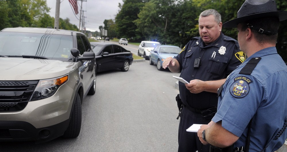Gardiner police Officer Eric Testerman, left, shares information Sept. 13, 2015 with Maine State Police Trooper Randy Hall on the Kennebec River Rail Trail in Farmingdale after a report of an assault there.