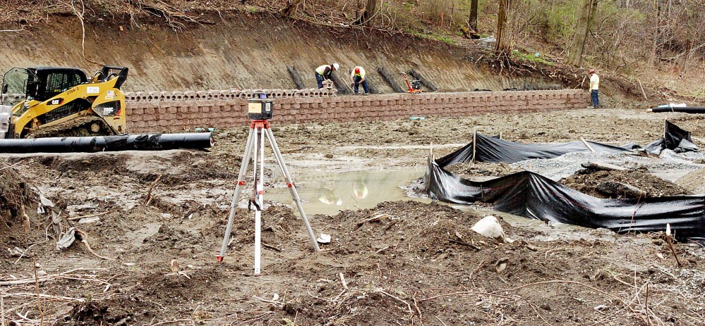 Workers with Ranger Contracting Inc. work on a retaining wall in the rear of a lot at 50 Bay St. in Winslow where a new Dunkin' Donuts is being built. It will replace the one at 9 Bay St.