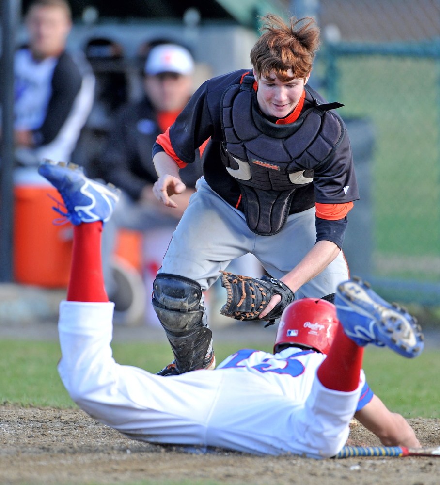 Skowhegan catcher Will Stinson looks to tag a Messalonskee runner during a 2014 game. Stinson, now a senior, is a force behind the plate for the Indians this season.