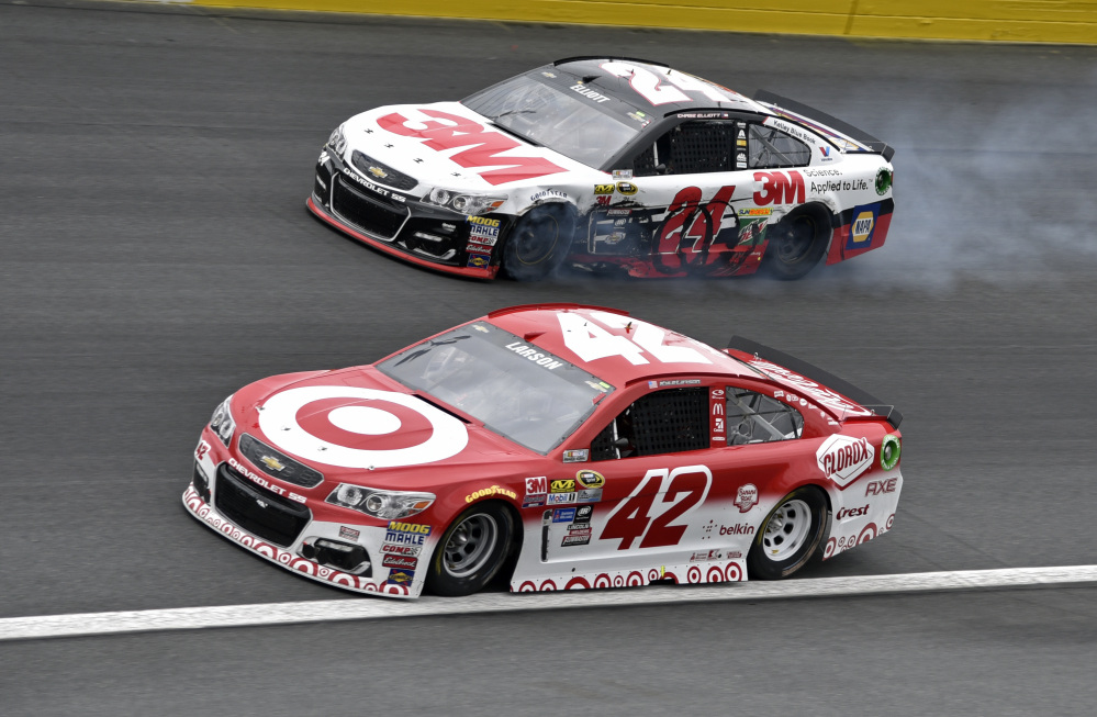 Smoke billows from Chase Elliott's car (24) as Kyle Larson drives past after the NASCAR Sprint Cup Series Sprint Showdown at Charlotte Motor Speedway in Concord, N.C., Saturday. Larson beat Elliott to the finish line to win the last segment of the race.