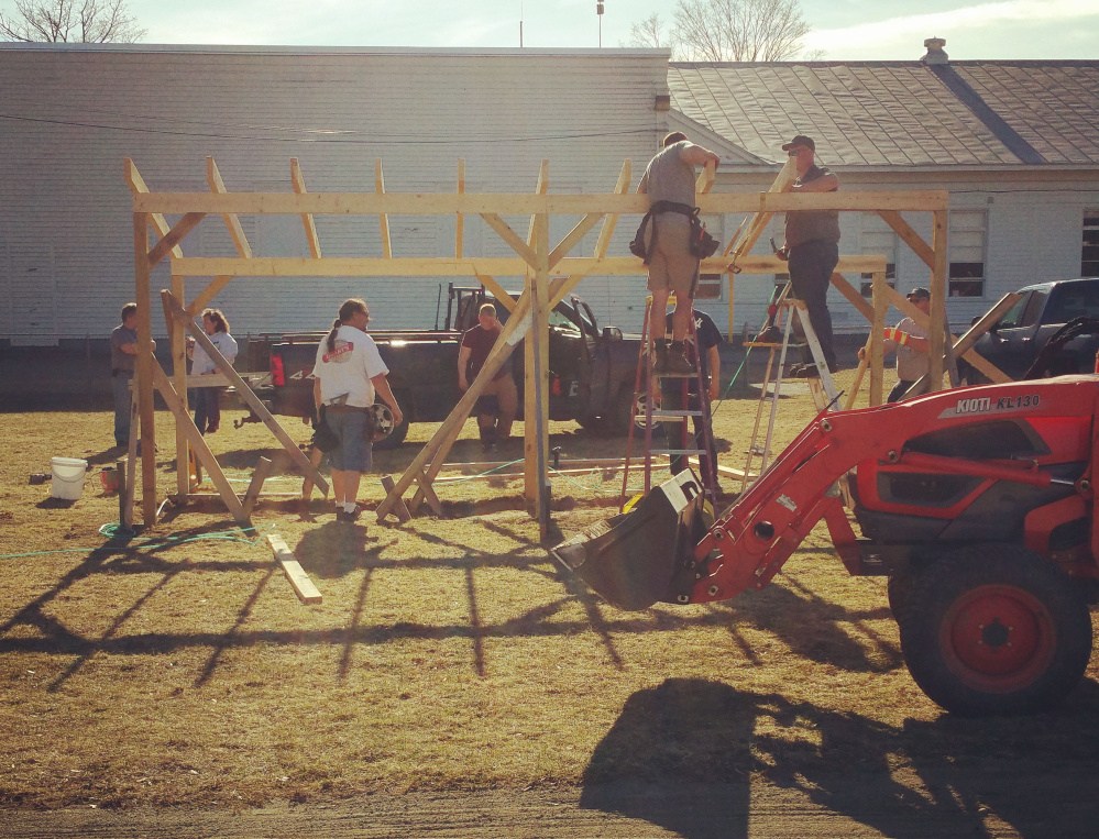 Volunteers build a dugout recently at the baseball and softball fields outside Quimby Middle School in Bingham.