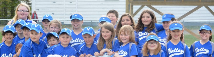 A group of young ball players pose at the baseball and softball fields outside Quimby Middle School in Bingham.
