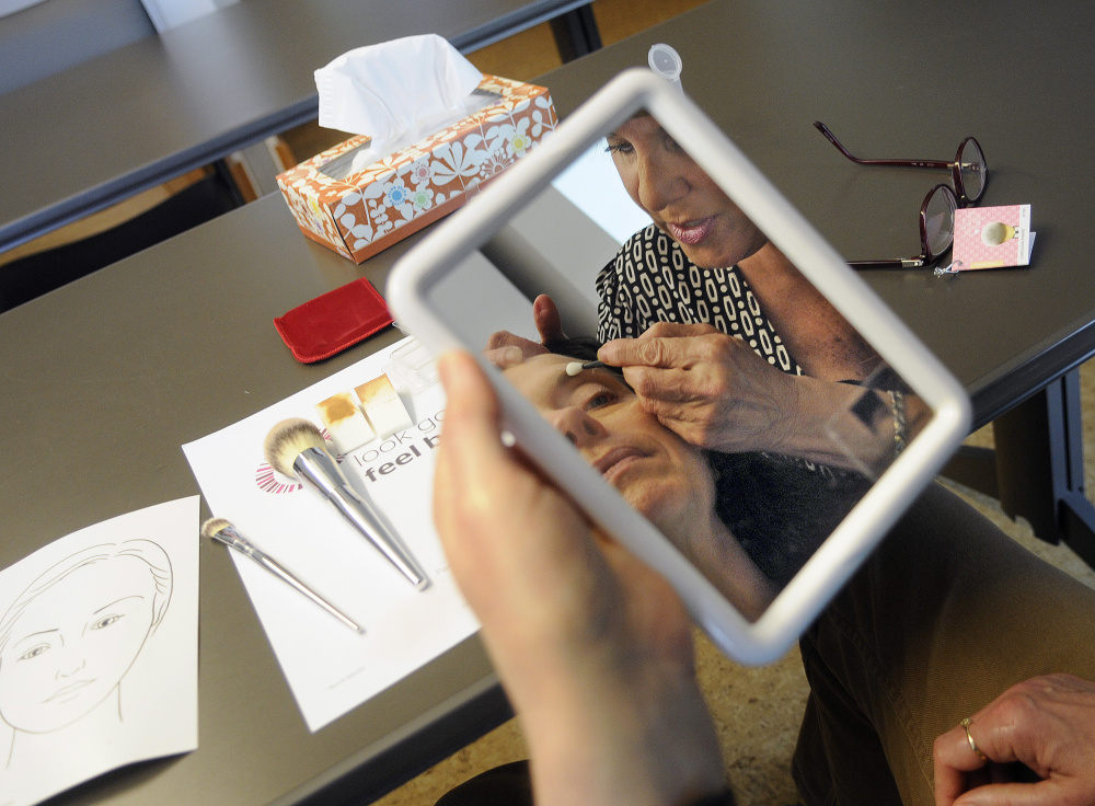 Victoria Littlefield, right, teaches Kenlyn Clark, of Waterville, how to apply makeup on Monday at the Alfond Center for Cancer Care in Augusta. The Pittston salon owner is being honored for her volunteer work helping women feel better while undergoing cancer treatments.