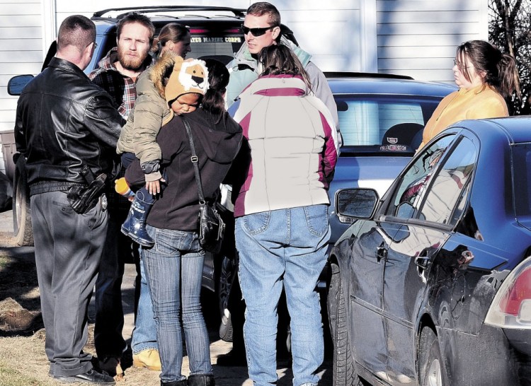 Maine State Police Detective Christopher Tupper, left, and Waterville Police Detective Lincoln Ryder, at right, speak with Justin DiPietro at his home on Violette Avenue in Waterville on Dec. 18, 2011, the day after he reported his daughter, Ayla Reynolds, missing. Beside DiPietro is his then-girlfriend, Courtney Roberts, holding a baby; his mother, Phoebe DiPietro; and sister, Elisha DiPietro, at right. Elisha DiPietro told the TV show "Crime Watch Daily" that they believe Ayla is still alive "out there somewhere." Ayla's mother's family wants Justin and Elisha DiPietro and Roberts charged in the toddler's death and is bringing a civil suit against them.