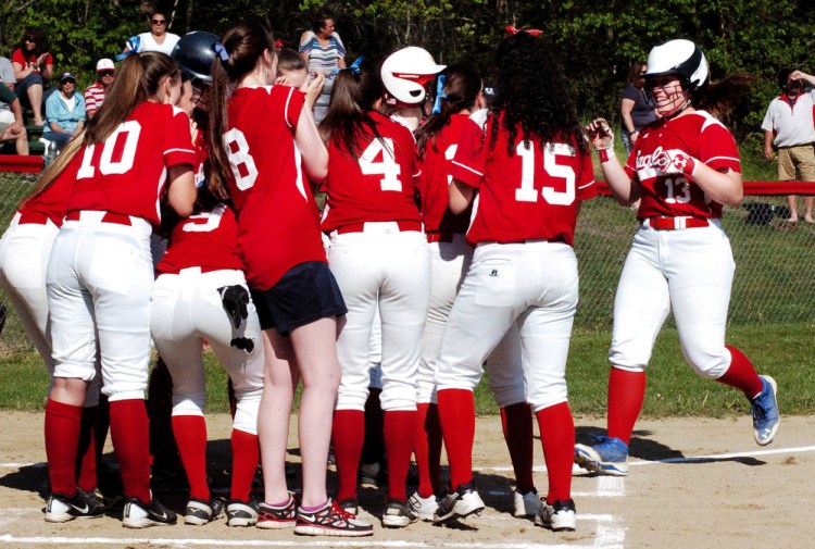 Messalonskee's Hannah Duperry is welcomed at home plate by a large greeting party after she belted a home run against Cony during a Kennebec Valley Athletic Conference Class A game Monday in Oakland.