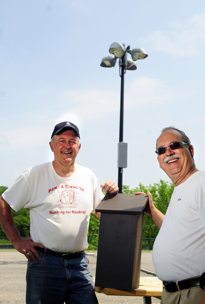 City Councilor Pat Paradis, left, poses with Ray Fecteau and a bat house Friday at the Mill Park pétanque courts in Augusta. Fecteau said he hopes the bats might eat bugs attracted to the lights at the court during evening play there.