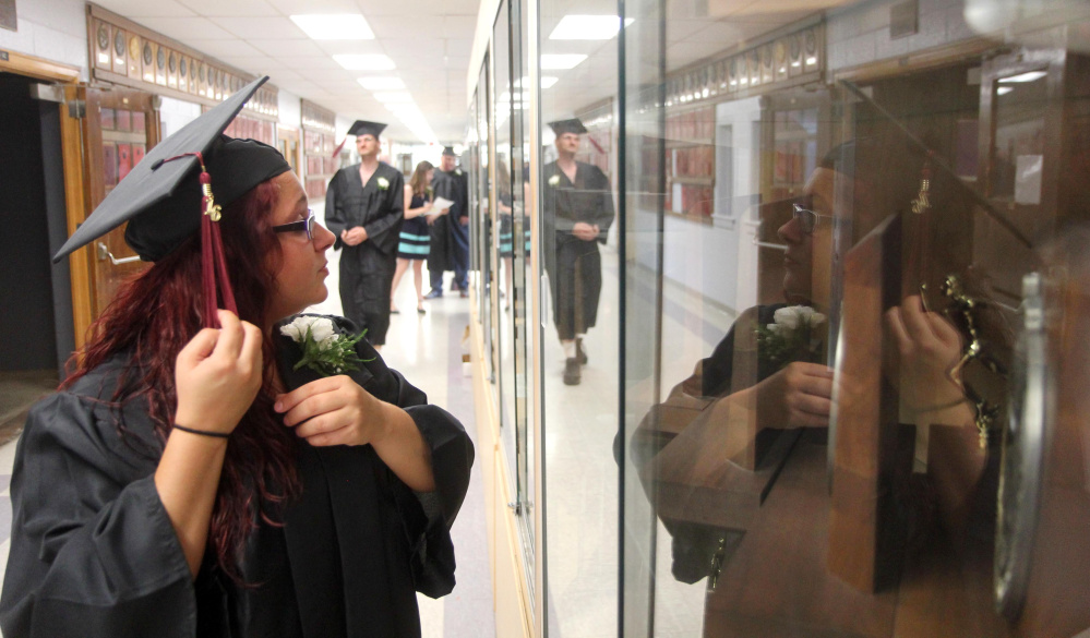 Crystal Hillman, of Albion, fixes her mortarboard Tuesday night before the start of the graduation ceremony at Mid-Maine Regional Adult Community Education at Waterville Senior High School.