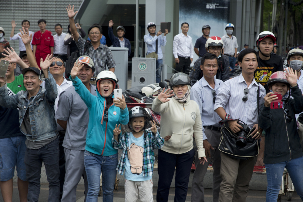 People gather and wave to U.S. President Barack Obama's motorcade as it travels to a Young Southeast Asian Leaders Initiative (YSEALI) town hall-style event in Ho Chi Minh City, Vietnam.