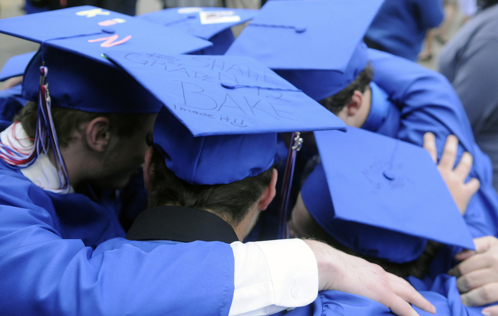 Messalonskee High School seniors huddle before graduation Thursday at the Augusta Civic Center.