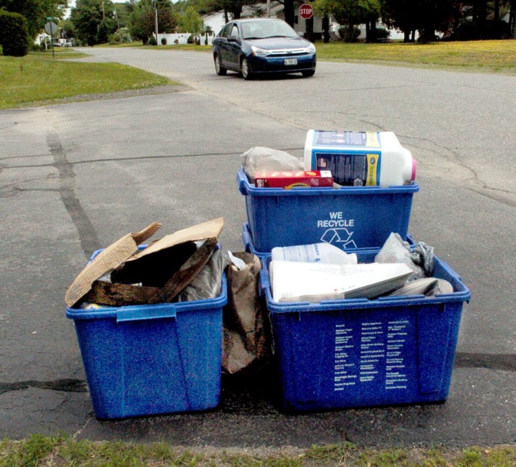 Recycling containers await pickup Thursday in Madison. Town residents will vote Monday at Town Meeting on a proposal to eliminate curbside recycling.