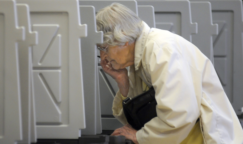 Peggy Pratt studies a question at the polls on Tuesday in Winthrop, where voters considered the school budget and a City Council race, among other things.