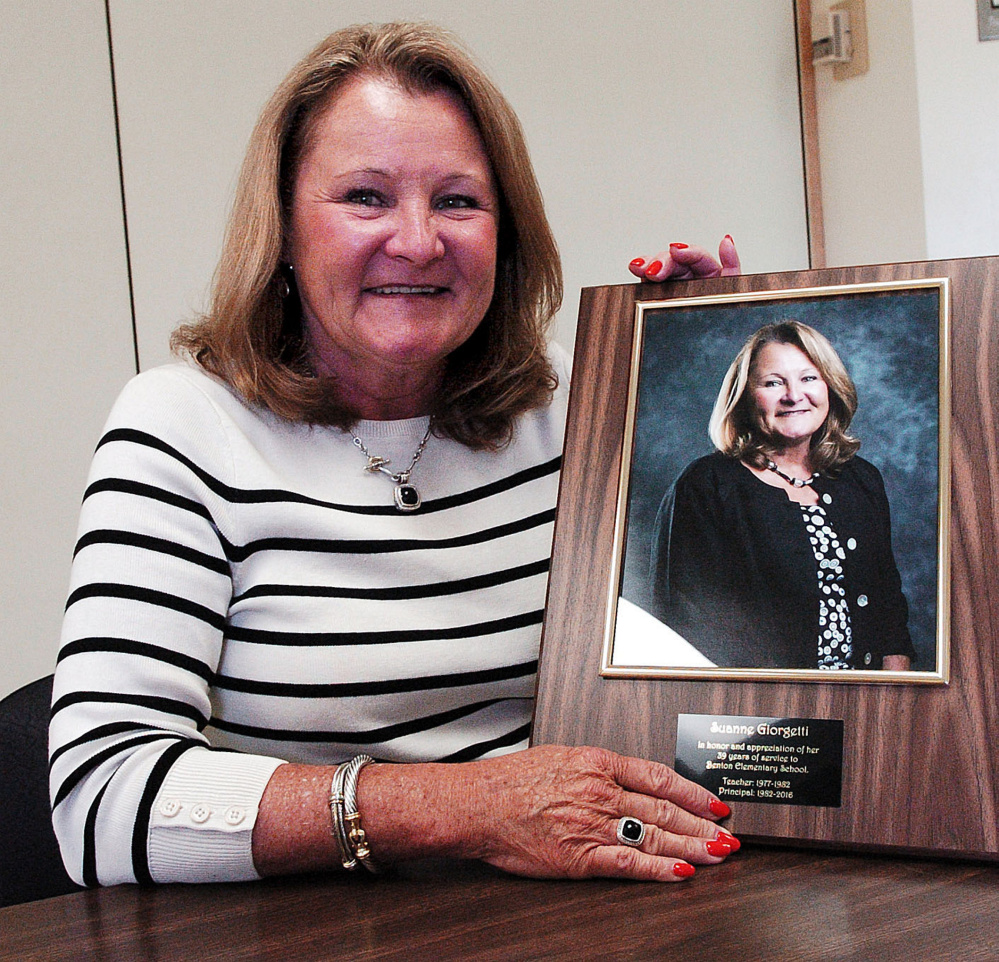 Students at Benton Elementary School give School Principal Suanne Giorgetti a portrait of her for her 39 years in education on Monday. Giorgetti retiring Tuesday.