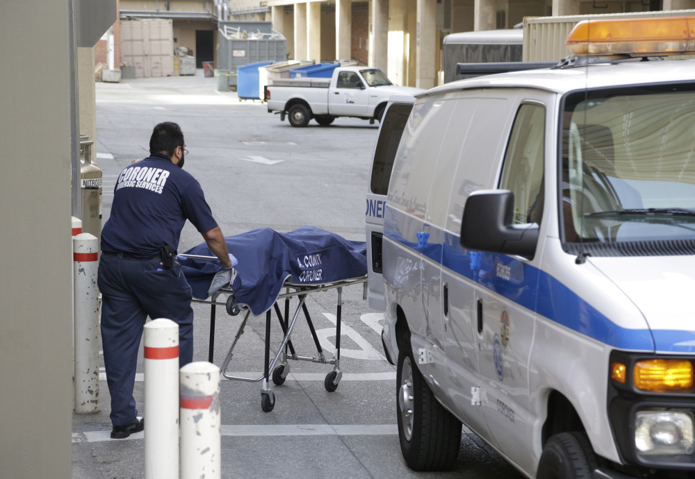 An employee of the Los Angeles County Department of Medical Examiner-Coroner's office removes a body at the scene of a fatal shooting at the University of California, Los Angeles June 1.