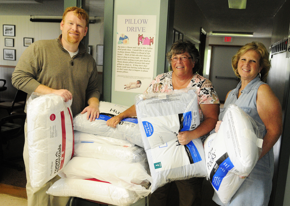 Selectman Jeremy Pare, left, Ann Young, treasurer, and Debbie Southiere, deputy clerk, pose with pillows on June 9 at the Manchester Town Office.