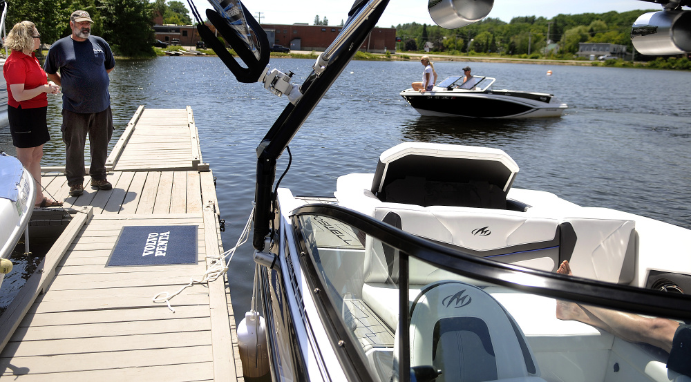 Nelson Lavigne inspects a boat with Pauline Gagnon at the docks on Maranacook Lake in Winthrop on Sunday. Gagnon Boats and Motors of Livermore Falls offered fathers a boat ride in exchange for a donation to the P.A.L.S. Cat Shelter in Winthrop.