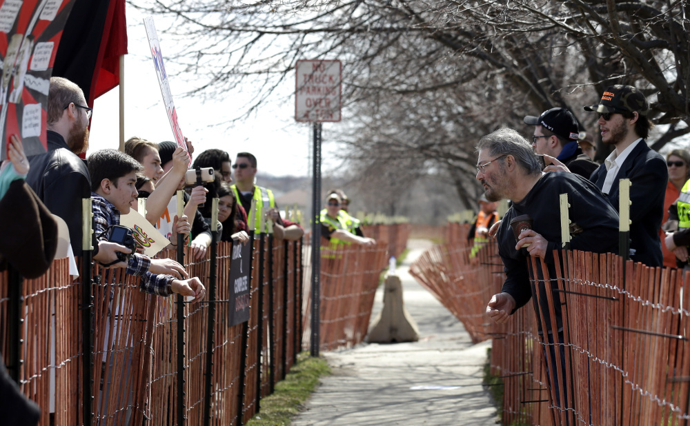 A sidewalk makes an uneasy buffer zone as supporters and opponents of Donald Trump face off outside the Republican presidential candidate's rally this past March in Janesville, Wis.