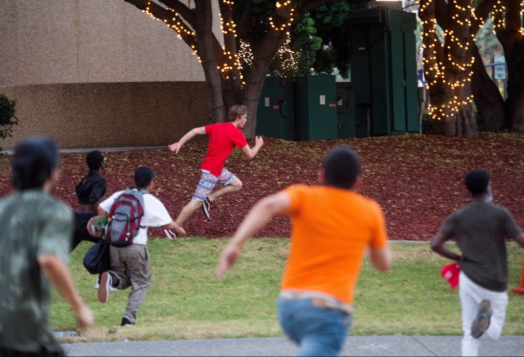 Protesters chase a man leaving the Trump campaign rally in San Jose, Calif. The Associated Press