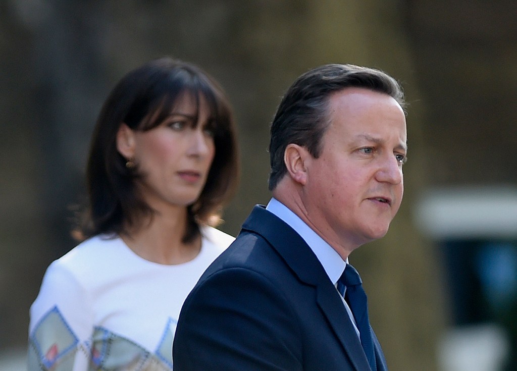 Britain's Prime Minister David Cameron speaks outside 10 Downing Street Friday as his wife Samantha looks on. Cameron says he will resign by the time a party conference takes place in the fall. PA via AP