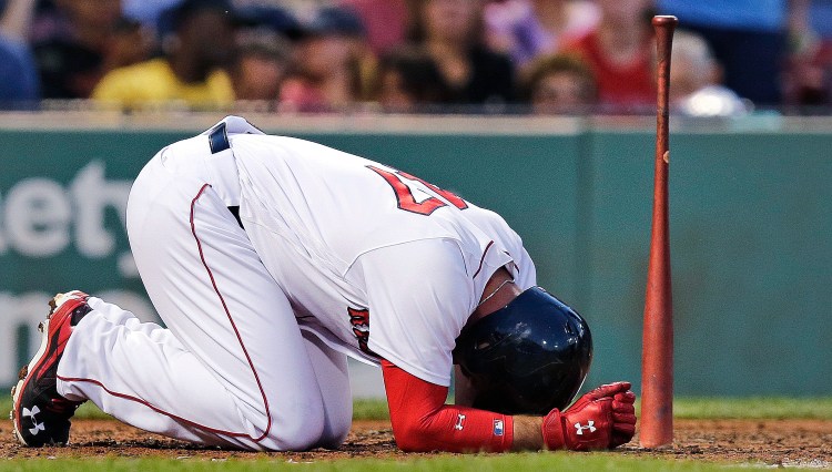 Boston's Travis Shaw kneels at home plate after getting hit with a foul tip during the fourth inning Tuesday. White Sox pitcher Chris Sale struck out nine Red Sox players as Chicago picked up a 3-1 win.    Associated Press/Charles Krupa