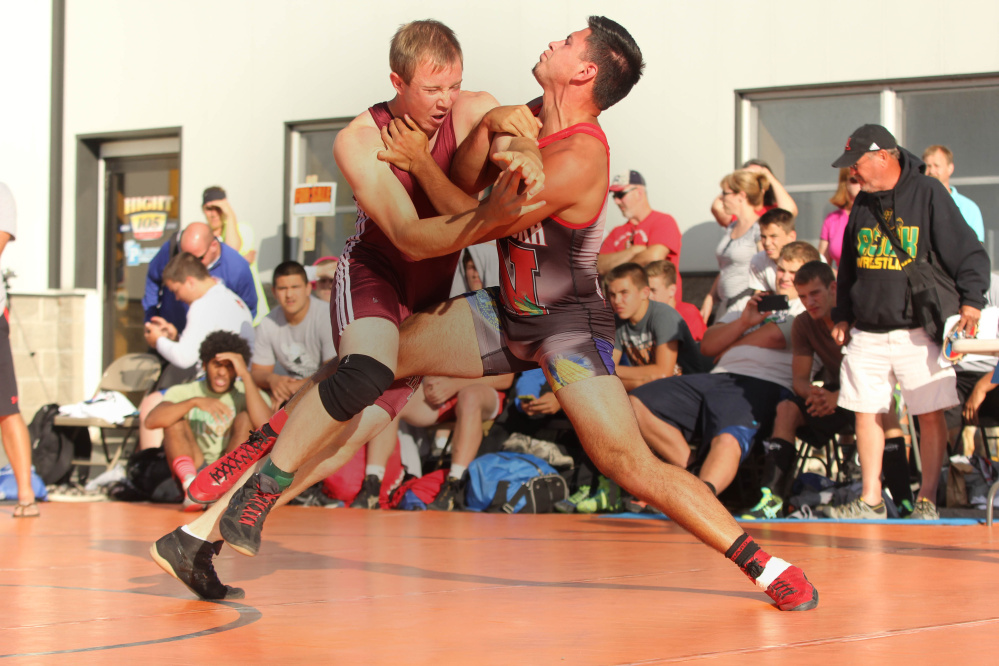 Nokomis Regional High School's Chris Wilson, left, battles Nebraska's Jacob Johnson during the 35th annual Maine-Nebraska wrestling exchange held Saturday in the Hight Chevrolet parking lot in downtown Skowhegan.