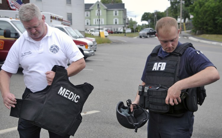 Augusta Fire Department Deputy Chief David Groder, left, with a safety vest and firefighter Anthony Thibodeau with a ballistic vest last week at Hartford Station in Augusta. The agency has been utilizing the vests for two years.