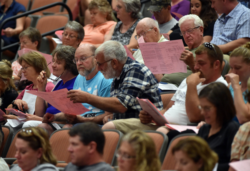 Regional School Unit 9 districtwide meeting participants examine budget documents Thursday at Mt. Blue High School in Farmington on Thursday.