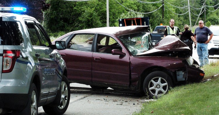 Fairfield police speak talk to bystanders at the scene of a one-car accident Monday on Center Road in Fairfield. The car's driver, Jeff Neill, was taken by helicopter to Central Maine Medical Center in Lewiston.