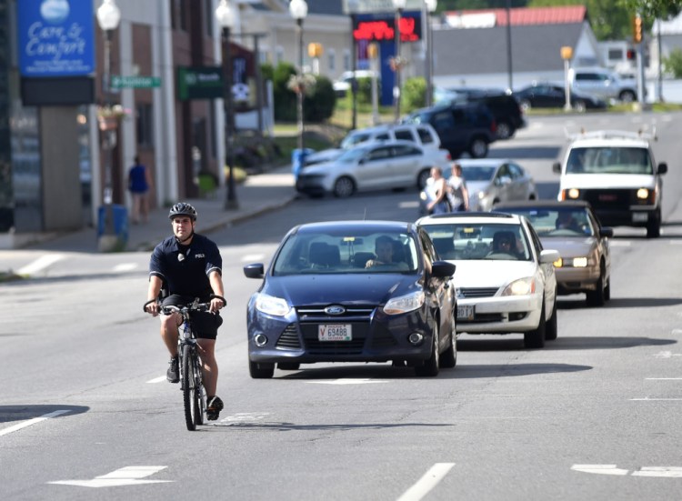 Waterville police Officer Kyle McDonald rides his police bicycle during his shift Tuesday down Main Street in Waterville. It's the 16th year of the patrol, which operates mostly in the summer.