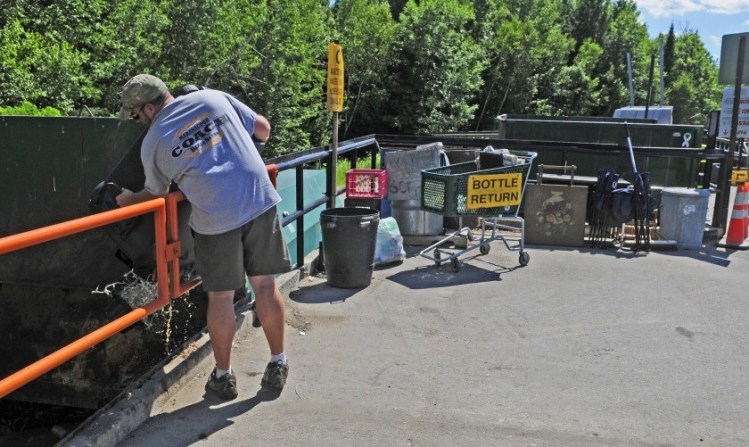 Scott Douin dumps a trash can Wednesday at the Readfield Transfer Station, where video surveillance cameras will be installed soon.