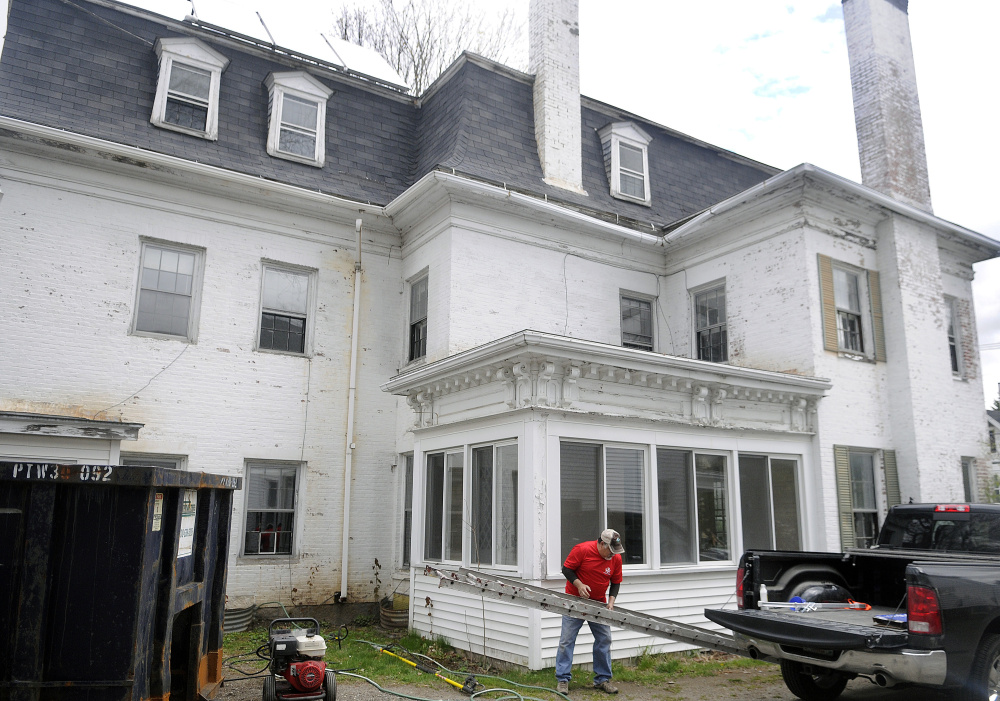 In this file photo, volunteer Norm Ginish unloads a ladder at the Betsy Ross House of Hope at 8 Summer St. in Augusta. 