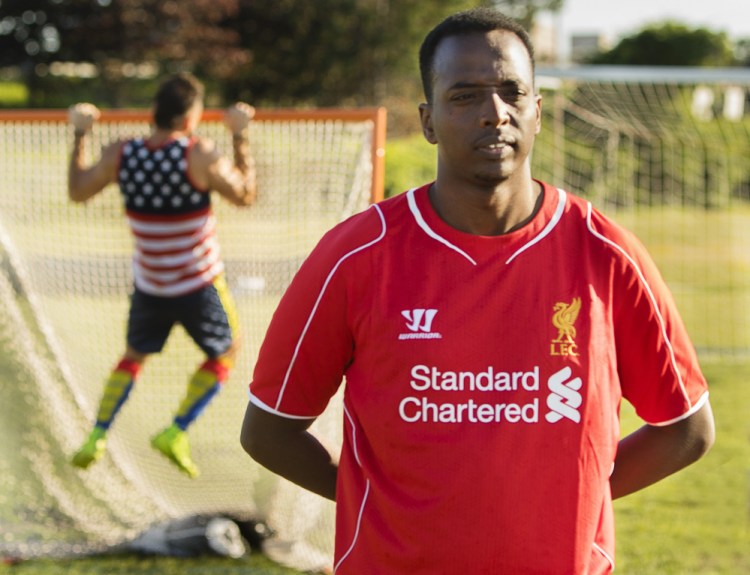 Abdi Nor Iftin waits to play soccer Thursday along Back Cove, with mostly immigrants like himself. Abdi grew up in Somalia, learned English there by watching U.S.-made movies and dreamed of coming to America.