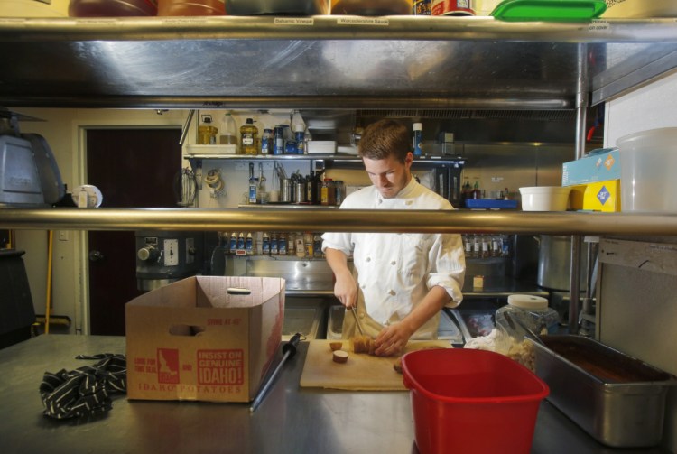 Brian Livermore cuts potatoes while doing prep work at David's KPT in Kennebunkport on Monday. Livermore, 18, plans to attend the culinary program at Southern Maine Community College this fall.   Gregory Rec/Staff Photographer