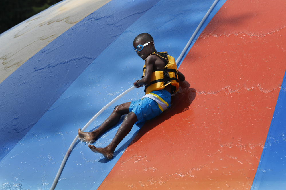 Noah Pacheco, 11, of New York City slides down the Aquasaucer slide Sunday at Aquaboggan Water Park in Saco. This is Noah's first year with his host family and as well as his first time away from New York City.