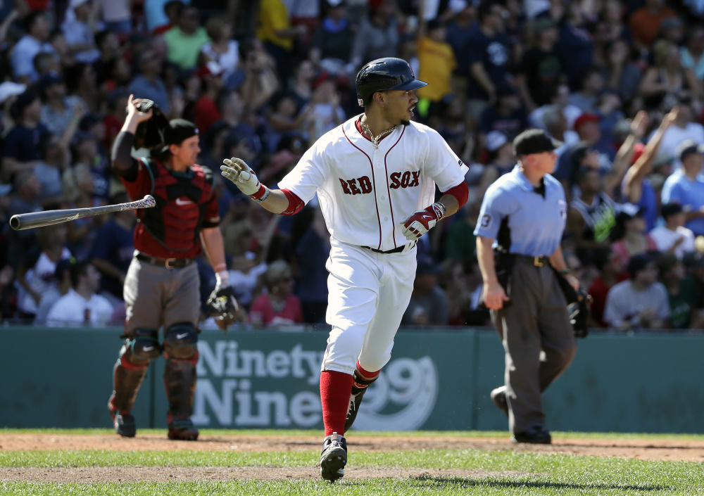 Boston's Mookie Betts watches the flight of his three-run home run as Arizona Diamondbacks' Tuffy Gosewisch looks on in the fifth inning Sunday at Fenway Park.