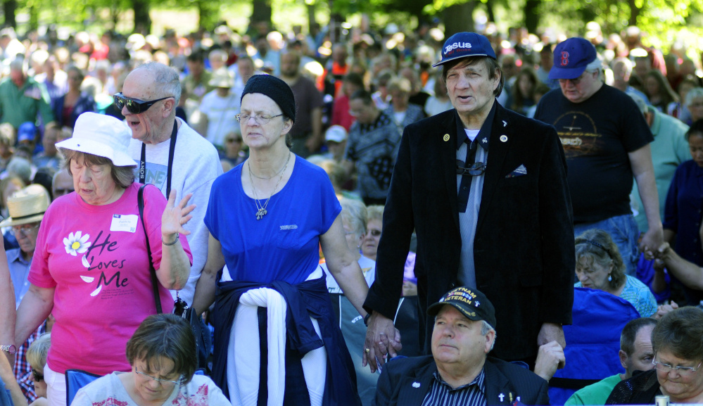 People pray during a rally led by Franklin Graham, the president of Samaritan's Purse and the Billy Graham Evangelistic Association, in Capitol Park on Tuesday in Augusta on his Decision America Tour. The park is across the street from the Maine State House.