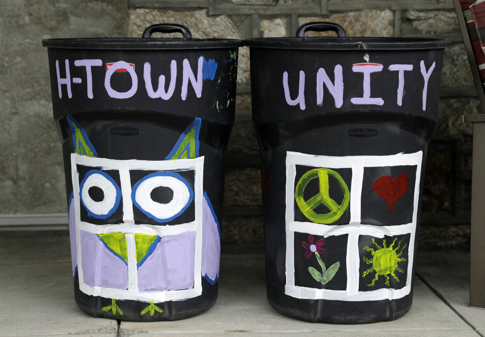 Megan Connell painted her trash cans, left, to show support for her neighbor whose trash bin was defaced with a swastika in Havertown, Pa. Esther Cohen-Eskin painted a flower over the swastika on her garbage can, above, and her neighborhood has rallied around the Jewish family.