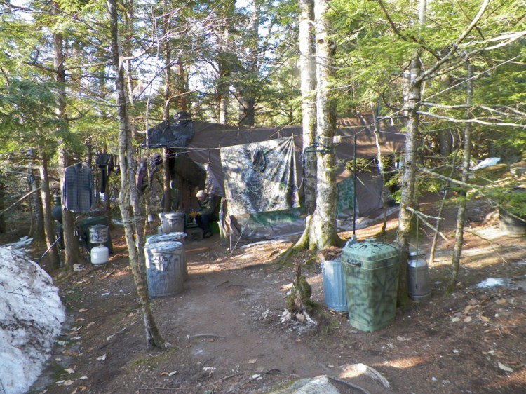 Christopher Knight sits at his camp in April 2013 in the central Maine woods after he led authorities to his campsite.