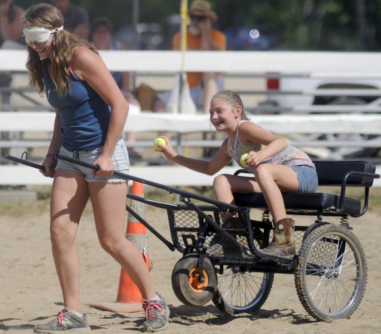 Elizabeth Simmons, 15, pulls her friend, Tayler Sevey, 14, through the Back Seat Driver Contest at the Monmouth Fair on Sunday.