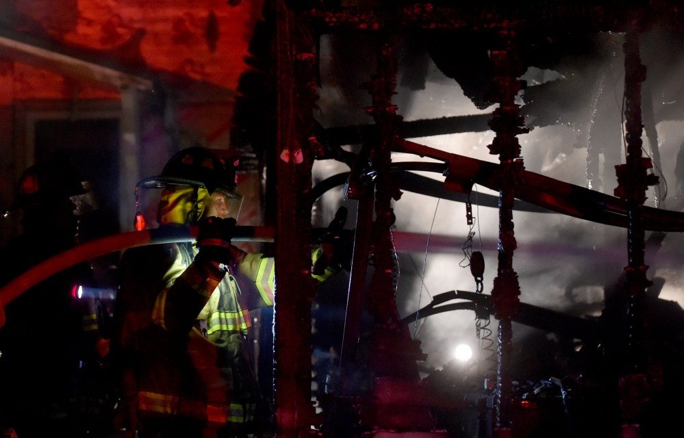 Firefighters from Waterville battle a fire that is believed to have been started in the garage and spread to a nearby boat and pick-up truck at 5 Belmont Ave in Waterville on Wednesday night.