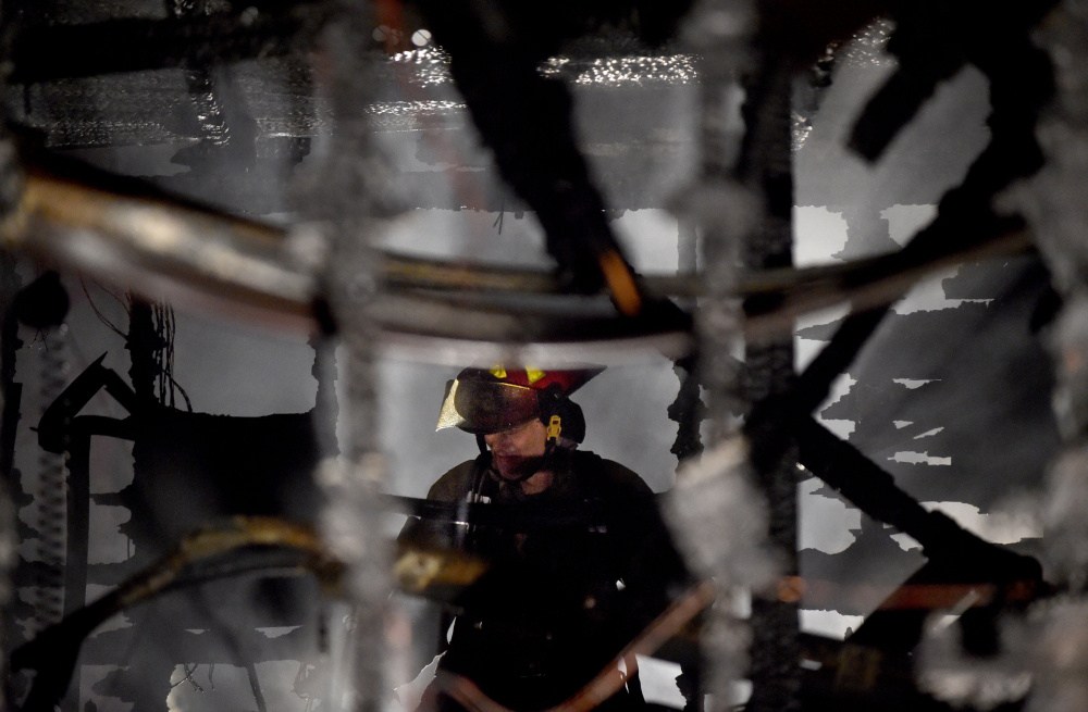 Firefighters from Waterville battle a fire that is believed to have been started in the garage and spread to a nearby boat and pick-up truck at 5 Belmont Ave in Waterville on Wednesday night.