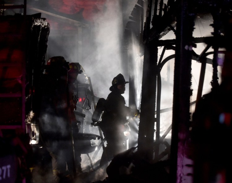 Firefighters from Waterville battle a fire that is believed to have been started in the garage and spread to a nearby boat and pick-up truck at 5 Belmont Ave in Waterville on Wednesday night.