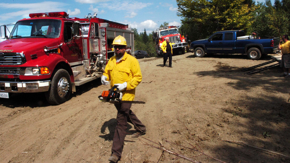 Firefighters from several area departments fought a woods fire Tuesday off Gray Road in Vassalboro. Winslow Chief Deputy Charles Theobald, background, directs trucks to the scene.