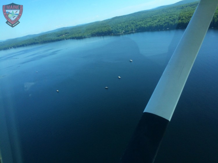 Watercraft towing search diving teams traverse the surface of Long Lake near the Naples-Harrison town line on Thursday.