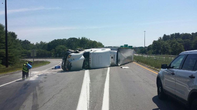 Cleanup underway on Thursday at the site of a truck rollover on the ramp from Route 1 to the Falmouth Spur of the Maine Turnpike.