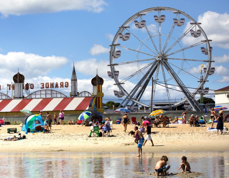 Beachgoers enjoy a beautiful day in Old Orchard Beach. Warm, dry weather has been good for tourism if not for farming.